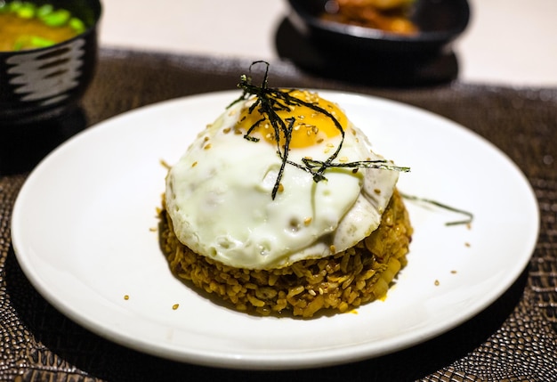 Kimchi bokkeum bap sul piatto bianco sul tavolo