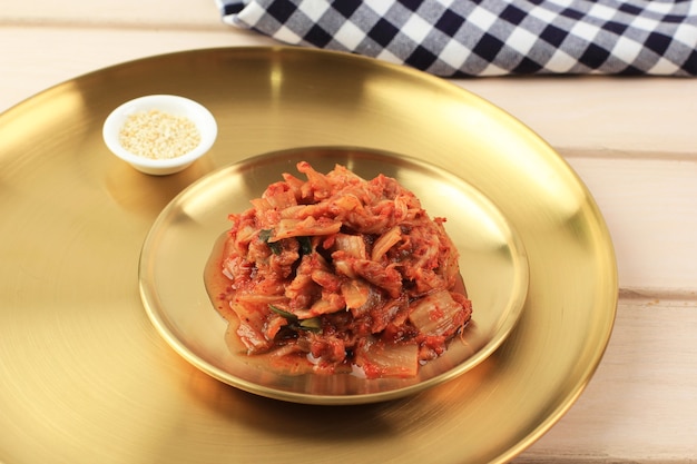 Kimchi, cavolo cappuccio fermentato tradizionale coreano Kimchi Pickle Insalata in ciotola di ceramica marrone con sfondo di legno. Copia spazio per il testo