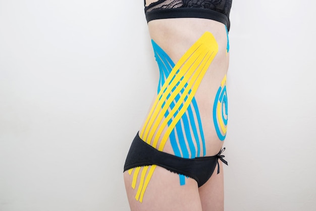 Kinesio tape ai lati dell'addome di una giovane ragazza