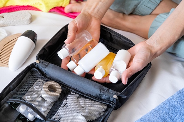 Kit di cosmetici da viaggio con bottiglie, pillole e cosmetici sulla vista dall'alto del letto