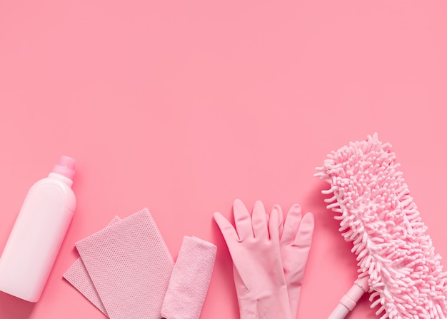 Kit di pulizia in casa rosa su uno sfondo rosa.
