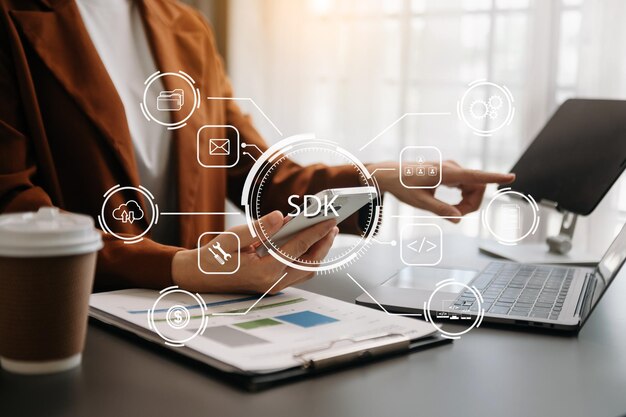 Kit di sviluppo software SDK concetto di tecnologia di linguaggio di programmazione Persona che scrive computer portatile e tablet con l'icona SDK sullo schermo virtuale xA