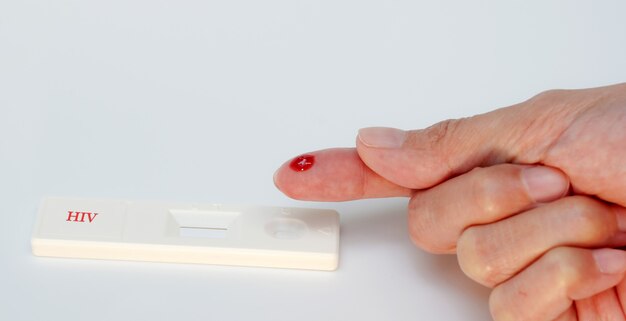 Kit di test rapido per HIV sfondo biancoSangue sul dito