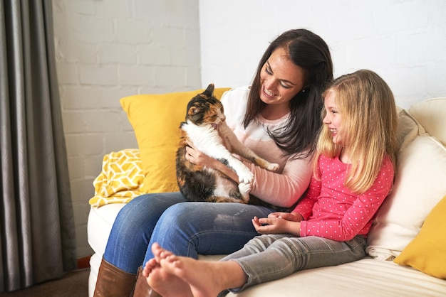 Kitty ci porta tanta gioia Foto ritagliata di una madre e una figlia che trascorrono del tempo con il loro gatto