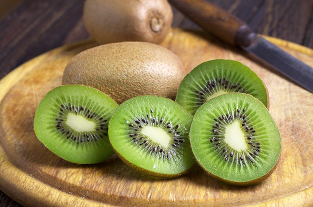 Kiwi affettato sulla vecchia tavola di legno. Foto da vicino