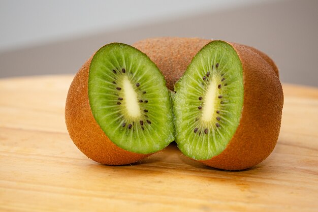 Kiwi marrone maturo affettato sulla tavola pronta per la vitamina di mattina