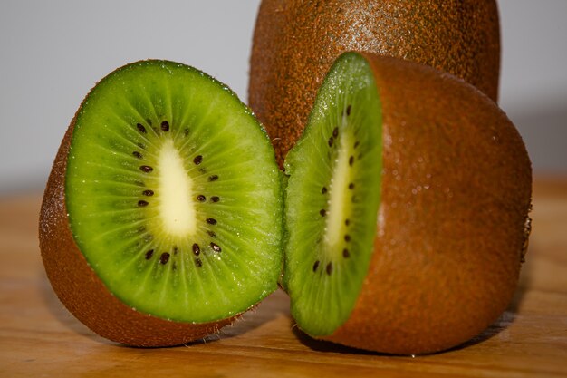 Kiwi marrone maturo affettato sulla tavola pronta per la vitamina di mattina