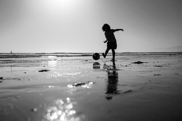 Kod gioca a calcio oa calcio sulla spiaggia durante le vacanze estive silhouette al tramonto