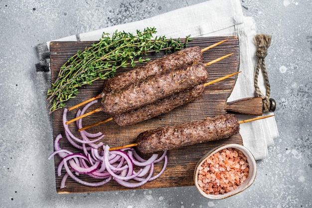 Kofta kofte alla griglia shish kebab di carne di agnello e manzo tritata su spiedino Sfondo grigio Vista dall'alto