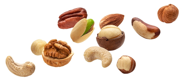 Photo koleksi kacang berjatuhan, mete, hazelnut, almond, kacang brazil, walnut, kacang tanah, pistachio, macadamia dan pecan diisolasi dengan latar belakang putih dengan clipping path