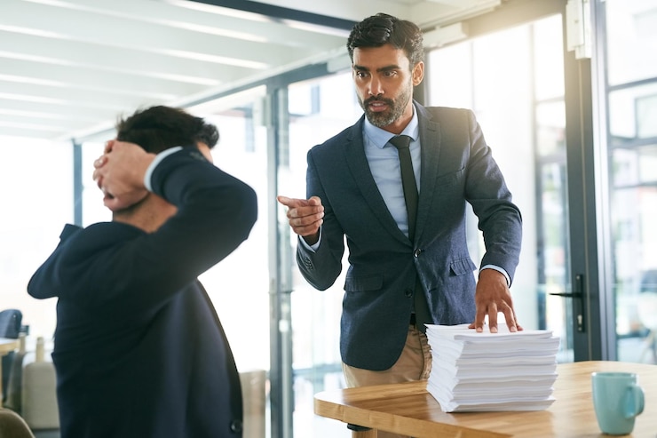 Photo konflik kerja atau tangan sdm menunjuk pengusaha di kantor dengan tumpukan kertas atau tenggat waktu beban kerja dan peringatan. kecemasan perusahaan atau manajer dengan stres atau tanda ancaman peserta magang untuk krisis audit