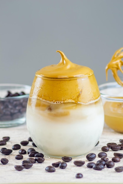 Kopi dalgona o dalgona caffè fatto mescolando zucchero di caffè istantaneo e acqua calda servito in un bicchiere