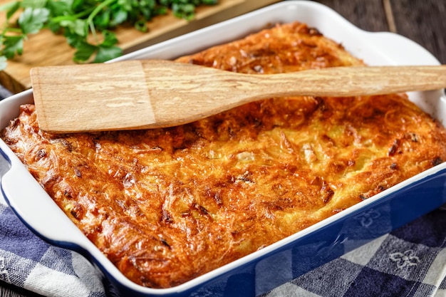 Kugel di patate salate budino al forno o casseruola di patate grattugiate in una teglia su un tavolo di legno festa ebraica ricetta closeup