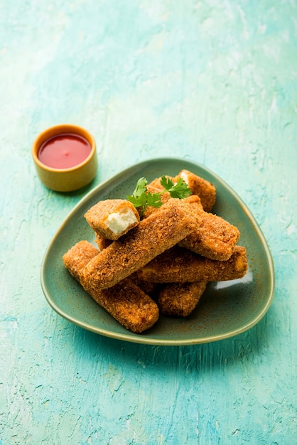 Kurkuri paneer finger o pakora, snack pakoda noti anche come barrette di ricotta croccanti, servite con ketchup di pomodoro come antipasto. messa a fuoco selettiva