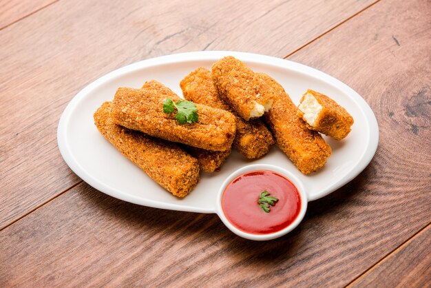 Kurkuri paneer finger o pakora, snack pakoda noti anche come barrette di ricotta croccanti, servite con ketchup di pomodoro come antipasto. messa a fuoco selettiva