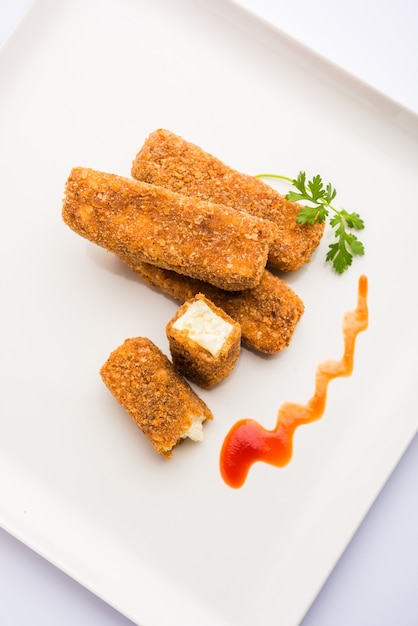 Kurkuri paneer finger o pakora, snack pakoda noti anche come barrette di ricotta croccanti, servite con ketchup di pomodoro come antipasto. messa a fuoco selettiva