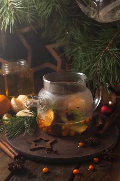 L'acqua bollente viene versata in un bollitore trasparente con frutta a fette e spezie all'interno