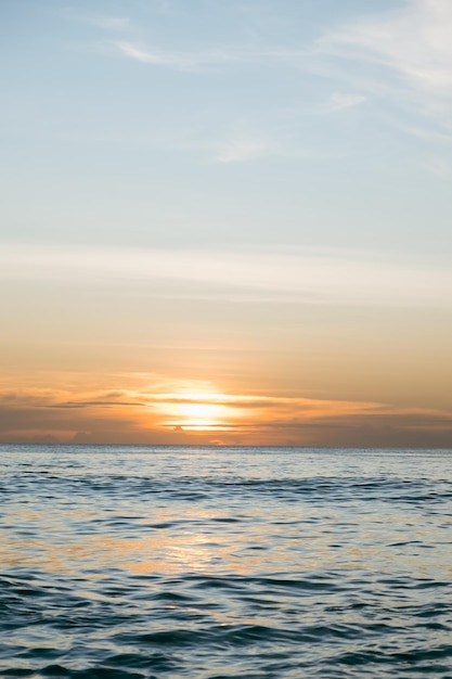 L'acqua calma del mare è illuminata dai raggi del sole al tramonto