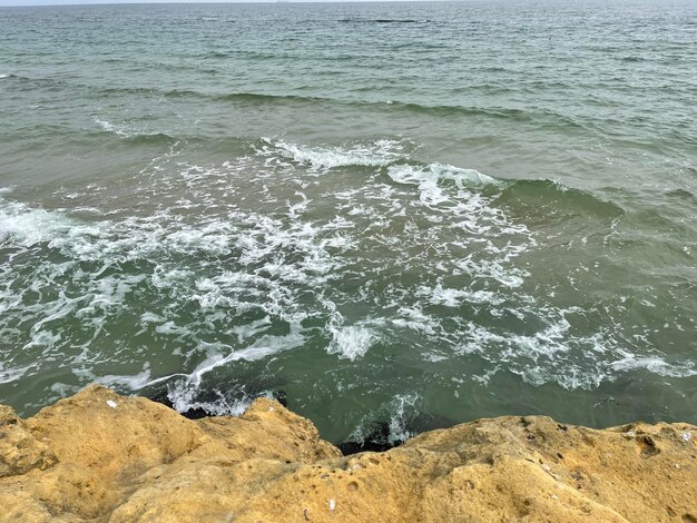 L'acqua di mare bagna la roccia gialla