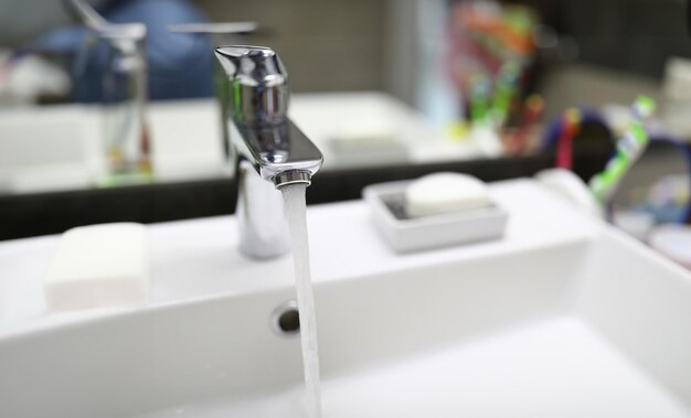 L'acqua scorre dal rubinetto nel lavandino del bagno