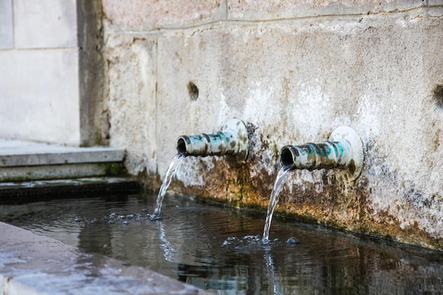 L'acqua scorre dal tubo ammuffito. acqua di sorgente naturale.