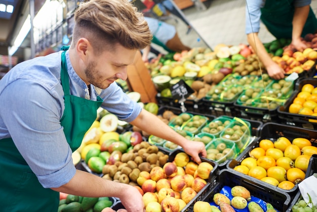 L'addetto alle vendite che afferra la cassetta della frutta