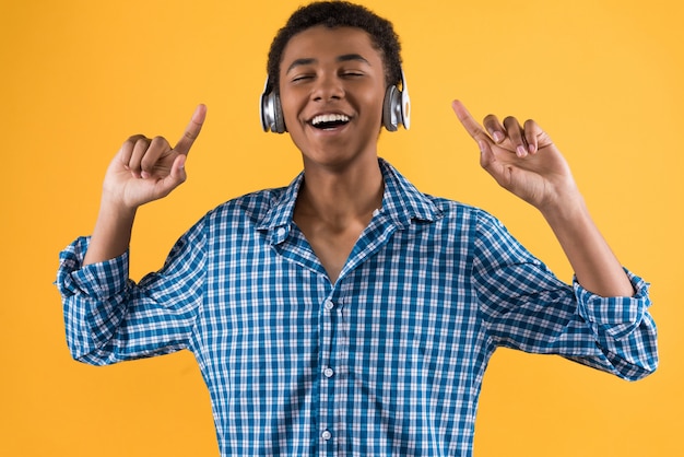 L'adolescente afroamericano in cuffie sta ballando.