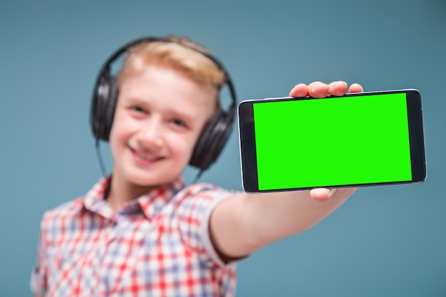 L'adolescente con le cuffie mostra il display dello smartphone