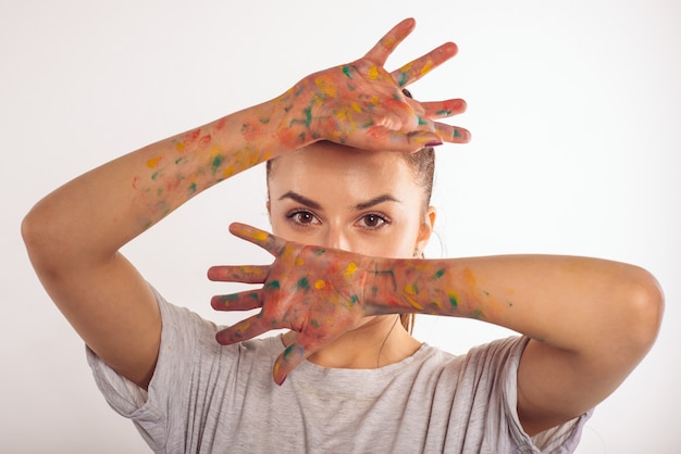 L'adolescente del ritratto si copre il viso con i palmi delle mani in vernice isolato su bianco