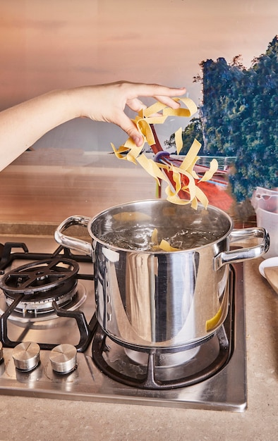 L'adolescente ha gettato la pasta nell'acqua bollente per gli spaghetti alla bolognese usando la ricetta da Internet.