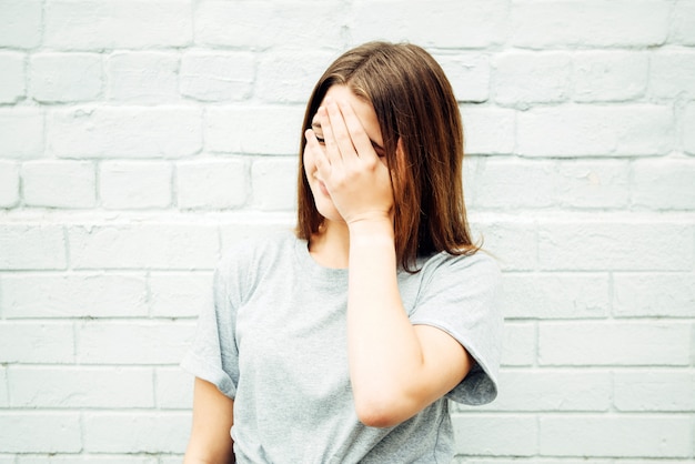 L'adolescente mostra il gesto di facepalm sulla strada.