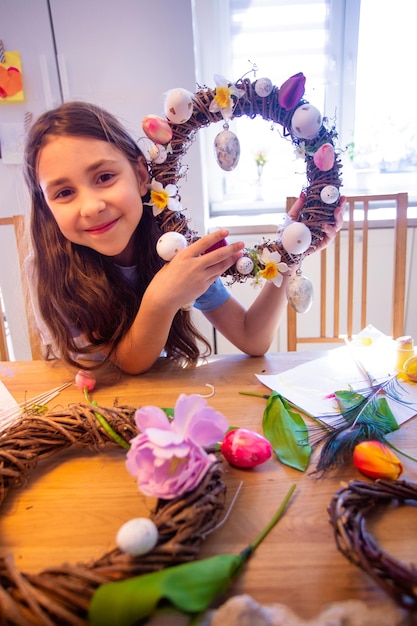 L'adolescente mostra la corona di Pasqua decorata a casa