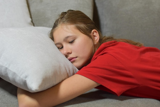 L'adolescente triste si trova sul divano di casa. depressione adolescenziale. incomprensioni in famiglia e a scuola