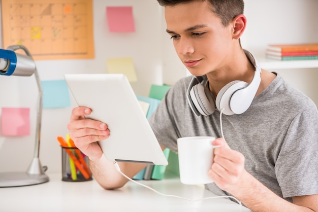 L'adolescente utilizza tablet e beve tè.