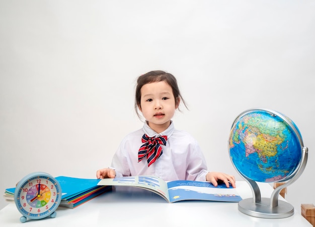 L'adorabile bambina sta imparando la geografia alla sua scrivania