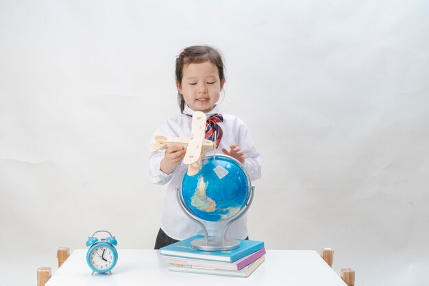 L'adorabile bambina sta imparando la mappa con un piccolo aereo