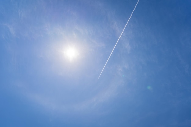 L'aereo passeggeri vola attraverso un cielo blu lasciando scie di vapore