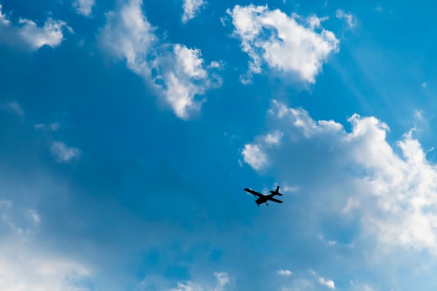 L'aereo stava volando nel cielo con nuvole bianche.