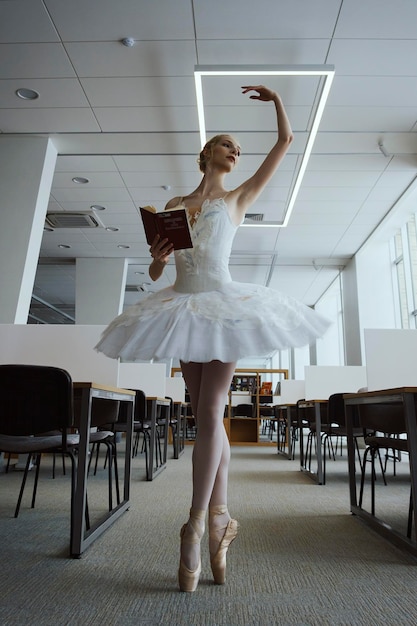 L'affascinante ballerina è andata in biblioteca per scegliere un nuovo libro durante una pausa che mostrava il tuo allungamento e flessibilità