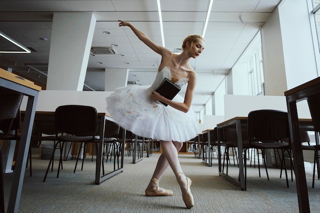 L'affascinante ballerina è andata in biblioteca per scegliere un nuovo libro durante una pausa che mostrava il tuo allungamento e flessibilità