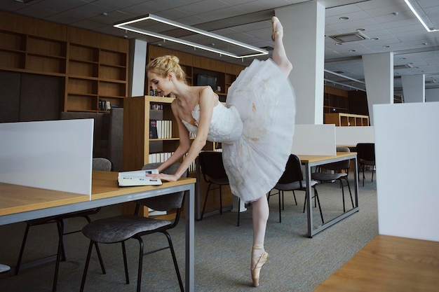 L'affascinante ballerina è andata in biblioteca per scegliere un nuovo libro durante una pausa che mostrava il tuo allungamento e flessibilità