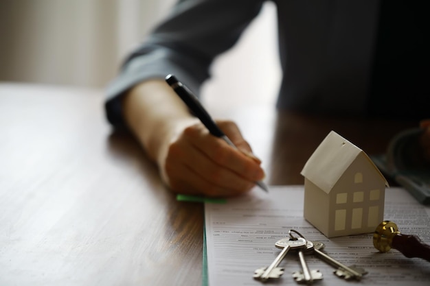 L'agente immobiliare ha parlato dei termini del contratto di acquisto della casa e ha chiesto al cliente di firmare i documenti Concetto di vendita e assicurazione della casa
