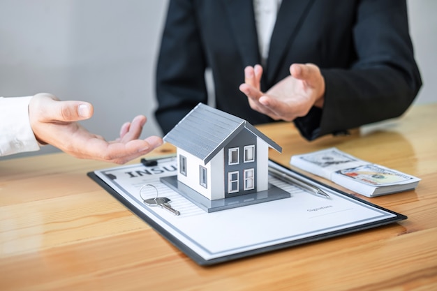 L'agente immobiliare sta presentando un mutuo per la casa e dando casa al cliente dopo aver discusso e firmato il contratto di accordo con un modulo di domanda approvato