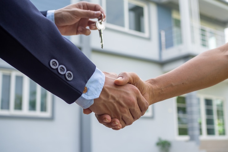 Foto l'agente vende la mano che stringe la mano con l'acquirente e invia la chiave di casa all'acquirente