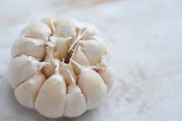 L'aglio è una spezia da cucina antiossidante, anticancro. Allium sativum. su tavola di legno bianca.