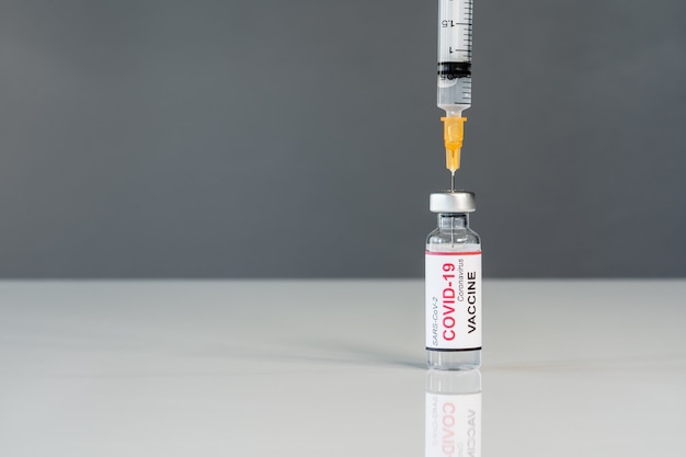 L'ago della siringa medica estrae il vaccino contro il Coronavirus (Covid-19) sparato da un vetro di bottiglia