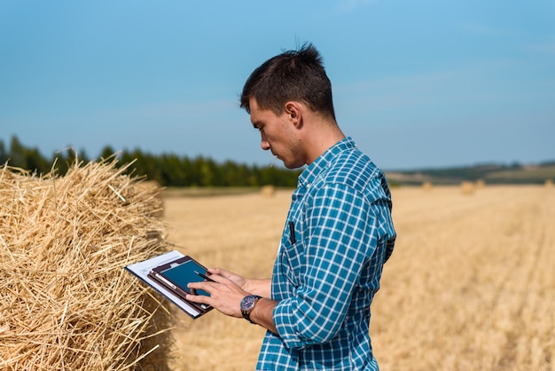 L'agronomo agricoltore nel campo utilizza tablet