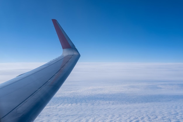 L'ala dell'aereo sullo sfondo di nuvole ondulate bianche e della stratosfera