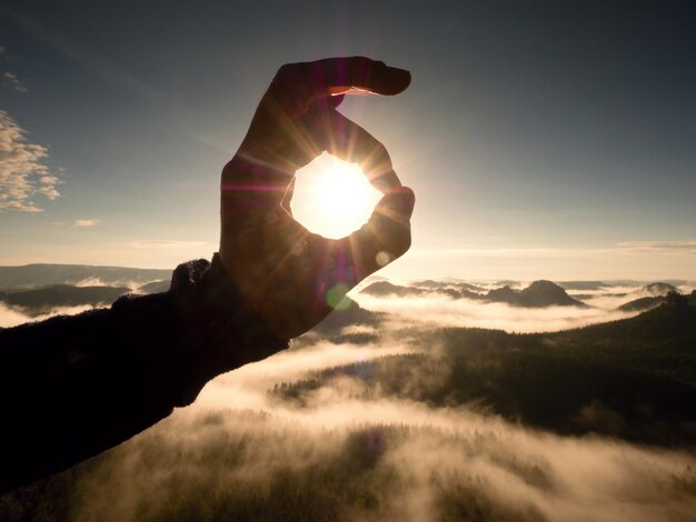 L'alba nebbiosa in una bellissima collina le cime delle colline sporgono dalla nebbia toccano il sole