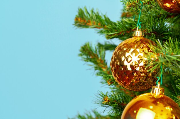 L'albero di Natale con le bagattelle dorate si chiude su sul blu